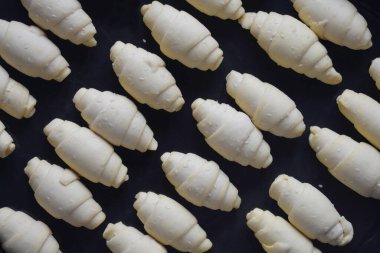 Fırınlanmamış kruvasanlarla dolu bir tepsi - üst manzara