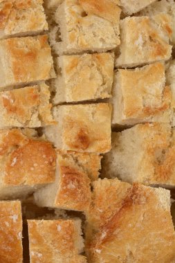 A close-up, full-frame shot of many small, square pieces of light-crusted bread, suitable for croutons, filling the entire image