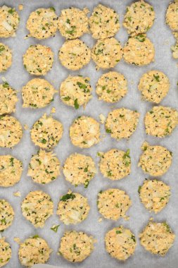 Daha çok doğranmış soya fasulyesi, soğan ve otlardan yapılan çiğ vejetaryen köfteleri, parşömen astarlı pişirme tepsisi üzerinde pişirilmeye hazırdır.