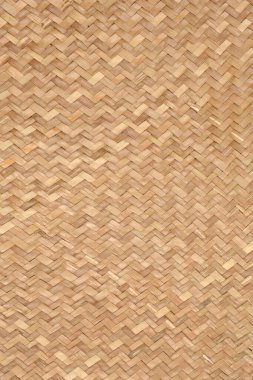 Tam kare yakın plan çekimde, açık kahverengi dokuma ya da sepet dokusunun dar, ringa kemiği ya da sembolü sergilenir.