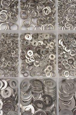 Çok bölmeli bir tepside çeşitli paslanmaz çelik yay yıkayıcıların çeşitli boyutlarını ve metalik dokusunu gösteren tepeden tırnağa, düzenli bir görüntüsü.