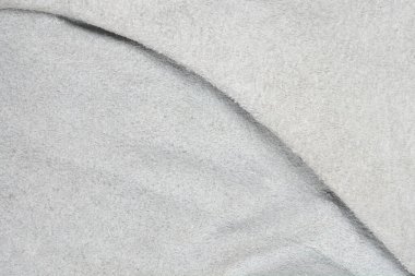 Yakın çekim açık gri süetin kıvrımlarını ve dokusunu ya da kıvrımlı ya da kıvrımlı deri malzemesini gösterir.