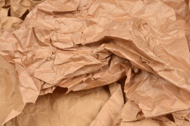 Buruşuk ve buruşuk kahverengi kraft kağıdından oluşmuş, organik ya da geri dönüşümlü temalı arka plan için mükemmel desenli bir yüzey.