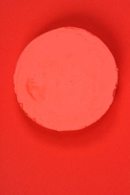 Kırmızı veya mercan modelleme kil yuvarlak bir parça katı kırmızı-turuncu arkaplan üzerine yerleştirilir, monokromatik bir kompozisyon oluşturur