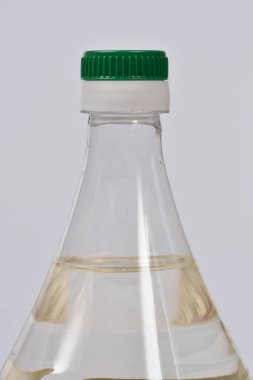 Yeşil başlıklı bir şişe şeffaf sirkenin yakın plan görüntüsü.