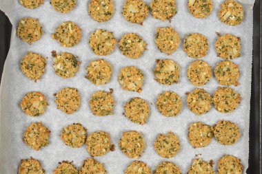 Soya, soğan ve tohumdan yapılan altın-kahverengi vejetaryen köfteler, pişirildikten sonra parşömen üzerine dizilir.