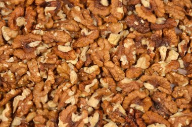 Yoğun bir şekilde paketlenmiş, organize edilmemiş, ceviz kabukları ve parçalarından oluşan tam kare yakın çekim, dokularını ve renk çeşitlerini gösteriyor.