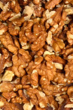 Yoğun bir şekilde paketlenmiş, organize edilmemiş, ceviz kabukları ve parçalarından oluşan tam kare yakın çekim, dokularını ve renk çeşitlerini gösteriyor.