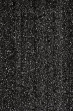 Kabataslak, pürüzlü siyah köpük dokusunun dikey yakın çekimi, ince dikey kaburga ile tüm çerçeveyi doldurur.