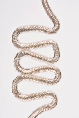 Yakın çekim, dikey çekim açık gri bir arka planda dalgalı, yılan desenli parlak bir ringa kemiği zinciri yakalar.