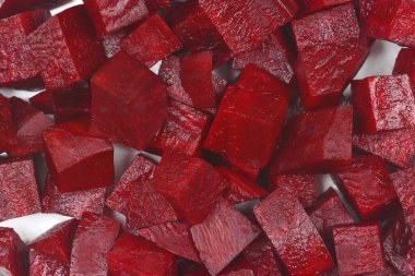 Makro tepeden çekimde yoğun, görsel olarak zengin, taze kesilmiş pancar kökü küpleri tüm çerçeveyi kaplıyor.