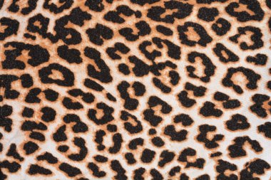 Tam kare çekim, klasik siyah ve kahverengi leopar desenli tekstilin ayrıntılı ve tekrarlayan desenini yakalar.