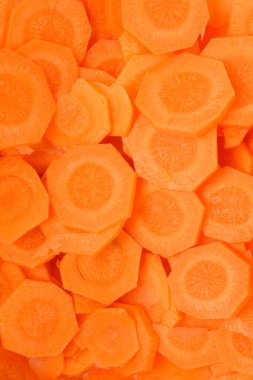 Canlı turuncu bir arka planın detaylı ve yakın plan görüntüsü tamamen yeni kesilmiş havuç dilimlerinden oluşuyor.