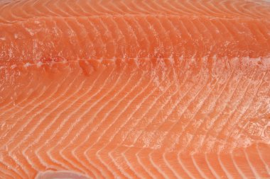 Çiğ somon filetosunun canlı turuncu ve pembe dokusunun yakın çekim, tam kare görüntüsü.
