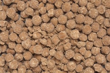 Yoğun, desenli, küçük, yuvarlak, kahverengi tapyoka incilerinden oluşan bir arka planın yatay yakın çekimi.