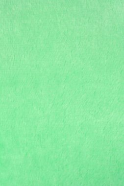 Yumuşak, yeşil, tüylü bir kumaşın yakın plan çekimi.