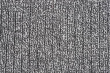 Yakın çekim tam çerçeve görüntüsü, sıcak, gri ve beyaz benekli yün veya iplik kumaşının dikey tırtıklı dokusunu yakalar