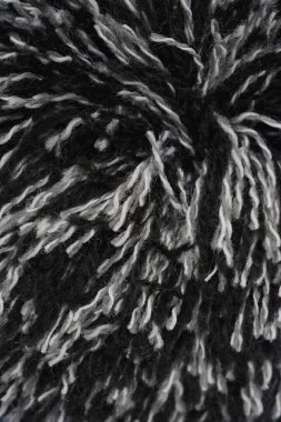 Yakın çekim, dikey çekim kalın yün veya akrilik ipliğin siyah beyaz veya gri liflerinin kabarık, tüylü dokusunu yakalar