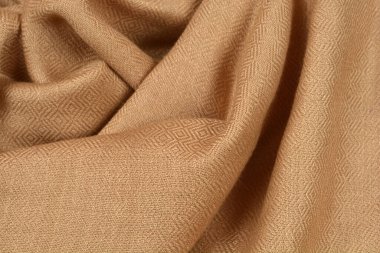 Deri kaplı kahverengi kumaş yumuşak kıvrımlı ve desenli yüzey kaplamalı karmaşık bir elmas deseni içerir.