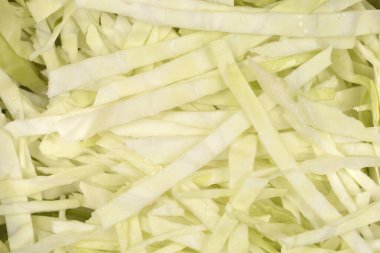 İnce dilimlenmiş taze beyaz lahanaların yakın çekim görüntüsü pişirilmeye ya da salataya hazır.
