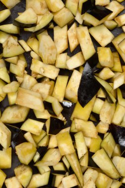 Taze patlıcan küçük düzensiz küplere bölünür. Soluk et ve koyu mor deri yakından görünür.