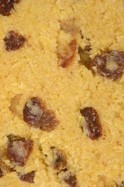 Detaylı makro çekim, içi kuru üzümle dolu çiğ Zaletti mısır unu kurabiyesinin dokusunu gösteriyor.