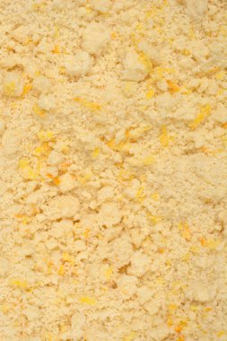 Tereyağlı, taze limonlu ve portakallı kurabiyelerle karıştırılmış sarı kısayol hamur hamurunun dokusunu gösteren ayrıntılı bir makro çekim.