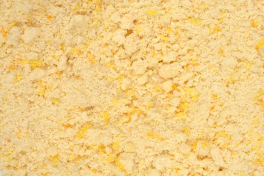 Tereyağlı, taze limonlu ve portakallı kurabiyelerle karıştırılmış sarı kısayol hamur hamurunun dokusunu gösteren ayrıntılı bir makro çekim.