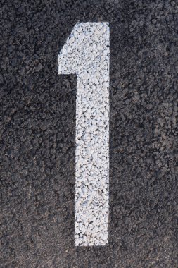 Koyu gri asfalt bir yüzeye desenli yol boyasıyla boyanmış büyük beyaz bir resmin yukarıdan aşağı manzarası.