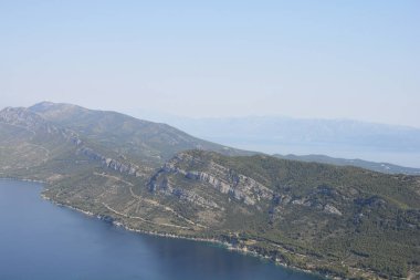 Sveti İvan zirvesinden çarpıcı yüksek açılı manzara, açık bir gökyüzünün altında Zuljana ve Trstenik arasındaki engebeli yeşil Peljesac yarımadasını gösteriyor.