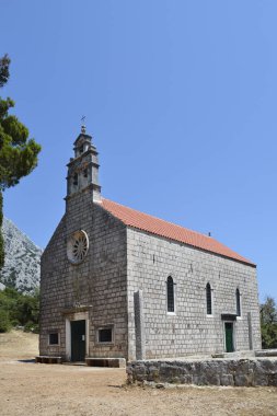 Carmel Dağı 'nın Leydisi' nin antik taş kilisesi Karmen 'de Peljesac yarımadasında Orebic yakınlarında açık mavi bir gökyüzüne karşı duruyor.