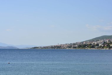 Krikvenica kasabasını gösteren kıyı manzarası açık bir gökyüzünün altında Krk Köprüsü ile mavi Adriyatik Denizi boyunca Selce 'den görülüyor..