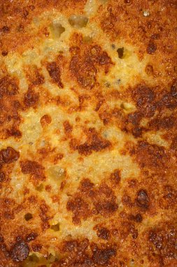 Lezzetli ev yapımı kızarmış Fransız tostunun gevrek altın rengi kahverengi dokusunu ve gözenekli yüzeyini gösteren detaylı bir makro çekim.