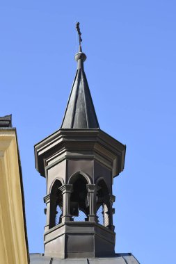 Karanlık metal kilise kulesinin alçak açılı görüntüsü ve Zagreb 'deki İsa' nın Kutsal Kalbi Kilisesi 'nin kulesi açık mavi gökyüzüne karşı.
