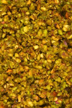 Detaylı bir üst çerçeve görüntüsü birçok küçük ezilmiş fıstığın canlı yeşil ve sarı dokusunu gösteriyor.