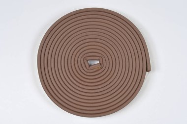 Bir rulo kahverengi yapışkan bant pencere kapama ve hava durumu şeridi için kullanılır beyaz arka planda izole