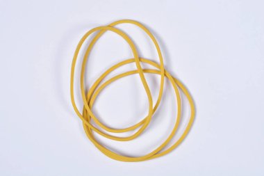 Birkaç ince sarı lastik bant sade beyaz arka plana saçılmış.