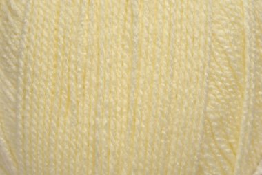 Soluk sarı yün ipliğin yumuşak dikey ipliklerini ve bükülmüş dokusunu gösteren ayrıntılı bir makro çekim.