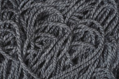 Karmaşık iplik dokusunu gösteren koyu gri örgü yün ipliğinin yakın çekim makrosu.