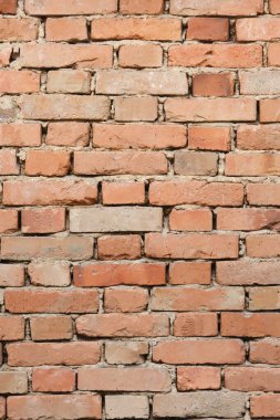 Görünür havan ve kırsal kil tuğlaları çeşitli turuncu ve kahverengi tonlarında eskimiş antika kırmızı tuğla bir duvarın ayrıntılı ön görüntüsü..