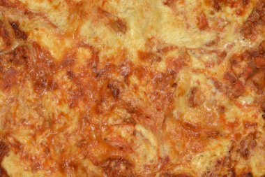 Yeni pişmiş bir lazanyanın detaylı makro çekimi çıtır çıtır kahverengi peynir kabuğu ve bol köpüklü et sosu dokusunu gösteriyor.