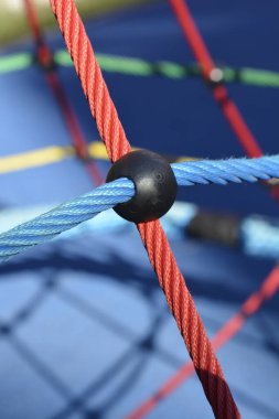 Kırmızı ve mavi örgülü ipleri kapatın. Çocukların dağcılık yapısına siyah plastik eklem ile bağlanın.