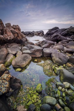 Gün batımında kayalık deniz manzarası. Arild, İsveç.