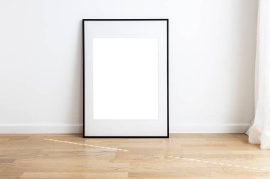 Dikdörtgen, ahşap döşemesi olan bir odada duran passepartou ile çerçeve oluşturur..