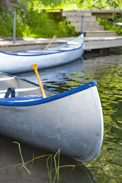 Empty canoes by the river — Stock Photo, Image