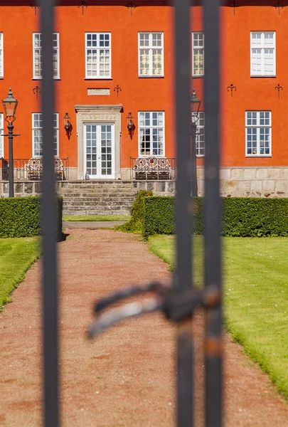 Edificio rojo detrás de puerta — Foto de Stock