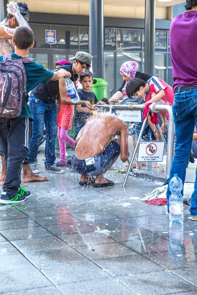 Refugee washing himself at the Keleti Trainstation in Budapest — стокове фото