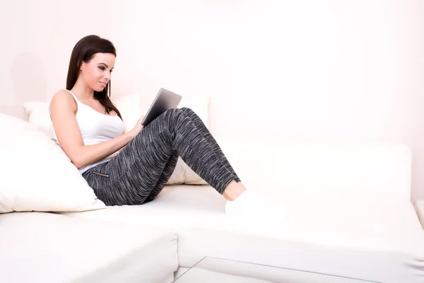 Jonge vrouw met behulp van een Tablet-Pc op de Bank — Stockfoto