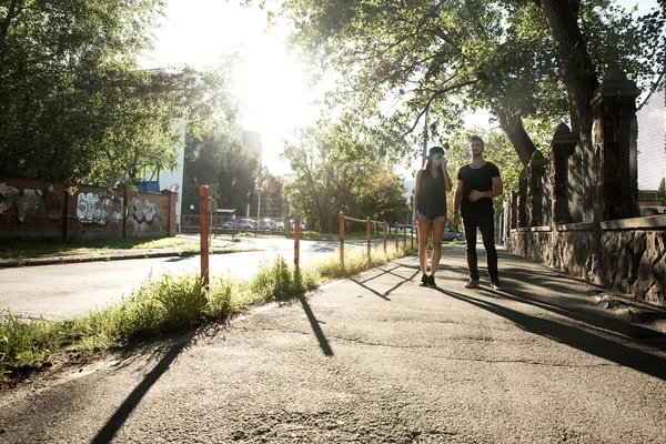 Ungt par talar i solnedgången i en stadsmiljö — Stockfoto