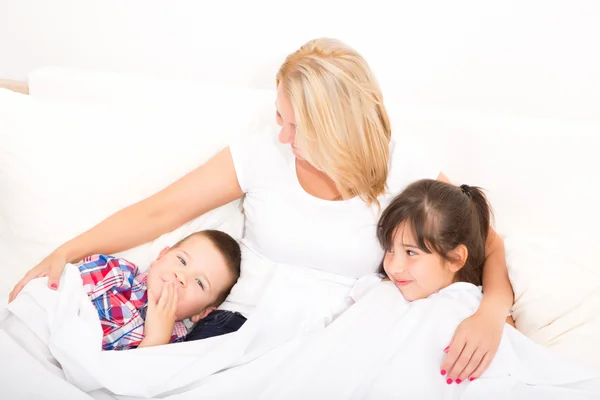 Moeder met dochter en zoon ontspannen in bed — Stockfoto